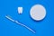 Toothbrush on bowl with tooth powder and tooth figurine on blue background. The view from the top. Flat lay.