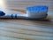 A toothbrush with a combination of blue and white on a wooden patterned plastic table