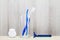 Toothbrush, interdental brush, dental floss and shaver in bathroom on wooden table on blurred wooden background