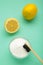 Toothbrush with lemon and baking soda on mint background. Vertical photo