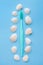 Toothbrush and a lot of seashells on a blue background. Vertical. Flat lay. Top view. Benefits of minerals for dental