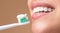 Toothbrush with toothpaste. Young cheerful woman brushing teeth with toothbrush during morning hygiene procedures