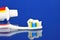 Toothbrush, tube of toothpaste, blue background. Oral hygiene products - toothbrush â€” a device for brushing teeth and gum