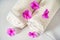 Toothbrush and white towels, pink flowers aromatherapy. Oral care, body hygiene and morning daily routines.