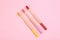 Toothbrushes made of bamboo on pink, flat lay