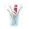 Toothbrushes and toothpaste for family in glass on white background