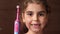 Toothless girl with an electric brush. The baby shows a toothless smile and an electric brush. Close up