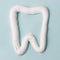 Toothpaste in the form of tooth, toothbrush on blue background. Dental hygiene concept