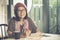 Toothy smiling face of asian woman reading pocket book in coffee