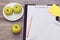 Top above overhead close up view photo of tasty healthy juicy green apples fruit note pad clipboad for making notes on wooden tabl