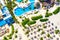 Top aerial drone view of beach with tourists, palms, sunbeds, swimming pools and straw umbrellas. Sea travel vacation. Dominican