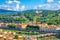 Top aerial panoramic view of green hills with Abbazia di San Miniato al Monte, bridges over Arno river, blue sky white clouds back