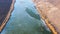 Top aerial view of the border of blue ice and green water on the river