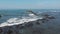 Top aerial view from flying drone above ocean landscape with big waves and rocks on black sand beach. Copy space for