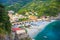 Top aerial view of green hill, railway, beach and harbor of Monterosso town village at sunset dusk, Genoa Gulf, Ligurian Sea, Nati