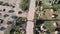 Top aerial view of pedestrian path promenade with palm trees and green grass. Drone flies over walking path near hotel area. Aeria