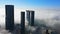 Top aerial view shot of skyscrapers in the city with fog clouds passing by - Abu Dhabi Al Reem island Sun and Sky towers