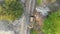 Top Aerial view on Tracked Bulldozer Rides on Sandy Road at Construction Site