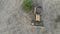 Top Aerial view on Tracked Bulldozer Rides on Sandy Road at Construction Site