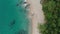 Top aerial view of tropical empty beach with turquoise sea water and rocks