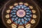 top angle shot: stained glass rose window of a gothic revival building