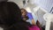 Top angle view of African woman dentist making professional teeth exam for young male dark skinned patient at the dental