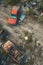 Top angle view of rusty cars and scattered debris on a deserted industrial ground.
