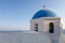 The top of a beautiful church with blue round roof in santorini, greece