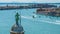Top of belfry with Saint George statue in Venice, traffic on Grand Canal, travel