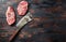 Top blade organic meat cut, raw marbled beef steak, with old butcher knife cleaver  On dark wooden rustic table, top view with