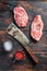 Top blade organic meat cut, raw marbled beef steak, with old butcher knife cleaver and seasonings  On dark wooden rustic table,