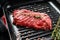 Top blade steak on a grill pan, raw meat, marbled beef . Black background. Top view