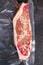 Top blade steak,  vacuum packed organic beef for sous vide cooking  on black textured background, top view