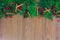 A top border of greenery with pine cones, cinnamon sticks, green ornaments, red berry clusters, and red ribbon