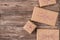 Top close up flatlay photo of pile of boxes packed in craft paper with red and white striped rope lying on wooden desk