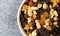 Top close view of a bowl filled with high energy trail mix on a gray mottled background in natural light