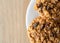 Top close view of homemade oatmeal raisin cookies on a white plate atop a table illuminated with natural light
