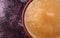 Top close view of a small bowl filled with sugar free applesauce on a maroon background