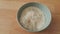 Top closeup view of heap of rice in a ceramic bowl placed over wooden floor