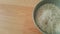 Top closeup view of heap of rice in a ceramic bowl placed over wooden floor