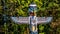 The top of the colorful `Thunderbird House Post Totem Pole` depicting a Thunderbird in Stanley Park