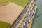 Top down aerial view of highway interstate road with fast moving traffic and parking lot with parked lorry trucks