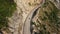 Top down aerial view over a motorist driving along dangerous cliffside road.