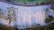 Top down aerial view panning over tropical coconut palms on white sand beach in late afternoon shade on island in the