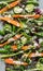 Top down close up view of a spring salad including carrots, asparagus and fiddleheads.