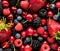 A top down macro view of a variety of berries including strawberries, blueberries, and cherries.