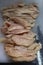 Top down portrait of raw chicken breast cut into strips on top of cutting board with chefs knife