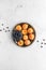 A top down view of apricots and a small bowl of blueberries on a metal tray. A complimentary colour concept.