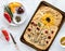 Top down view of a baked focaccia bread with various vegetables forming a flower garden design.