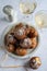 Top down view of a bowl of oliebollen (translation: Dutch dough fritters) with a glass of champagne on white background